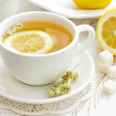 Чай с лимоном в белой чашке
